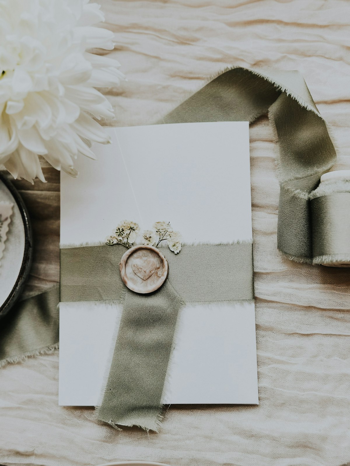 Une enveloppe du Club de lettres, nouée d'un ruban doux, scellée à la cire et parsemée de fleurs séchées